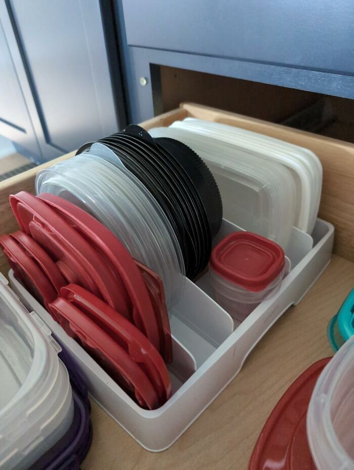 Organized Tupperware lids in a drawer, exemplifying efficient spring cleaning.
