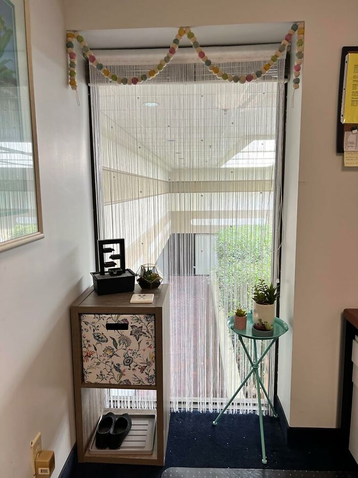 Beaded curtain with 80s style decor, featuring a floral cabinet and potted plants, evoking nostalgia for grown-up 80s kids.