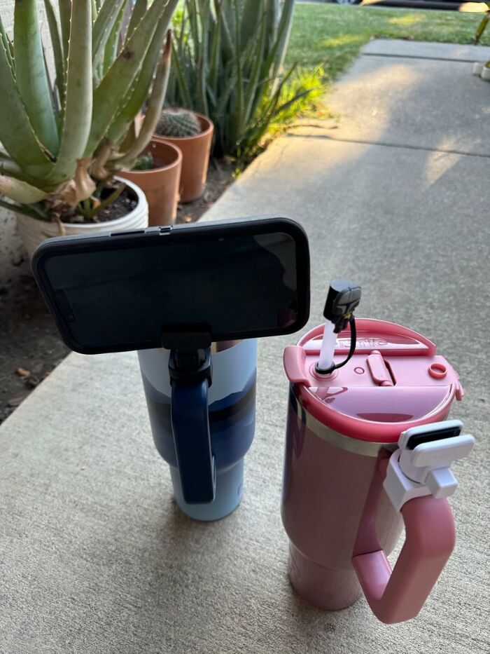 Two mugs with attached phone holders, showcasing random Amazon finds that spark joy, placed on a patio.