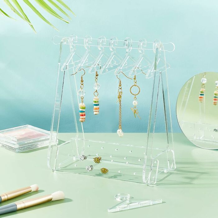 Clear jewelry stand displaying colorful earrings, designed to organize and showcase accessories in a stylish way.