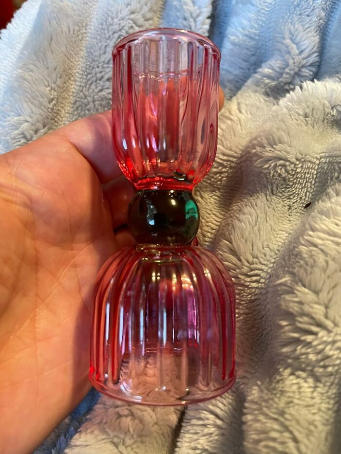 Red glass spring decor item held in hand, featuring a textured design.