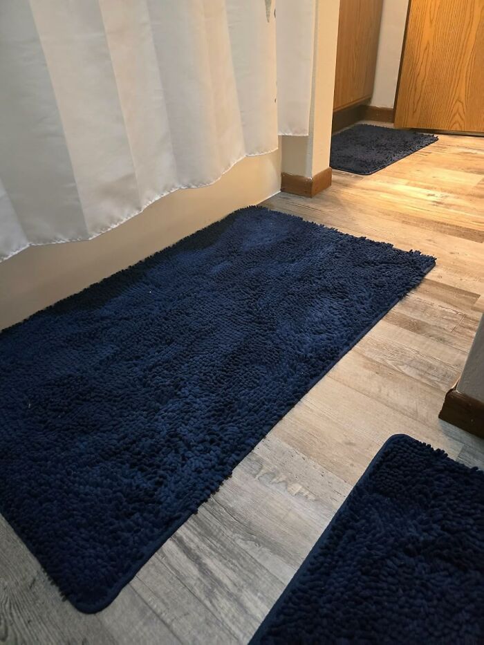 Blue bath mats on wooden floor, showcasing spring discounts on Amazon.