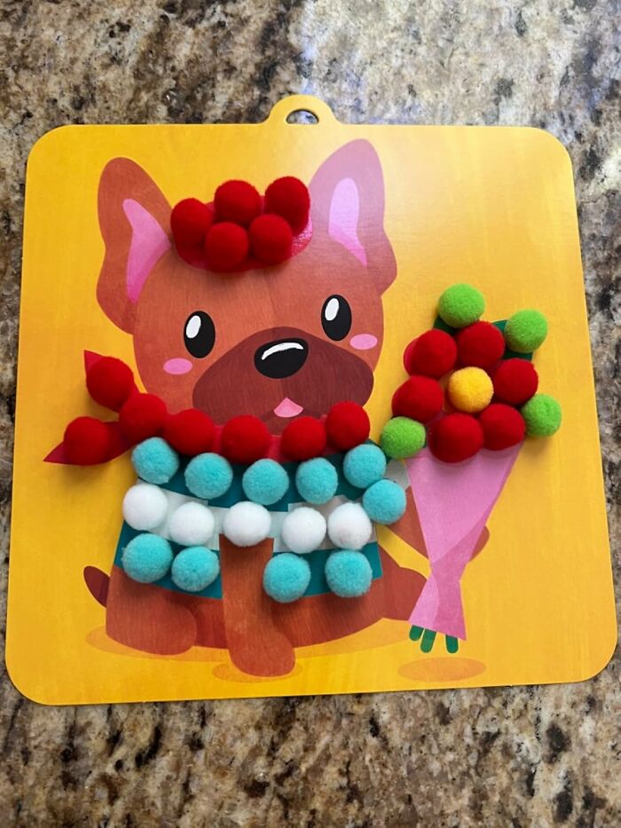 Colorful pom-pom puppy craft, an adorable Easter basket stuffer on a yellow background.