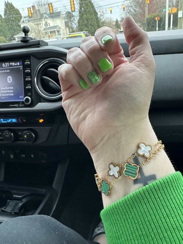 Spring bracelet and green nails in a car, showcasing stylish spring finds.
