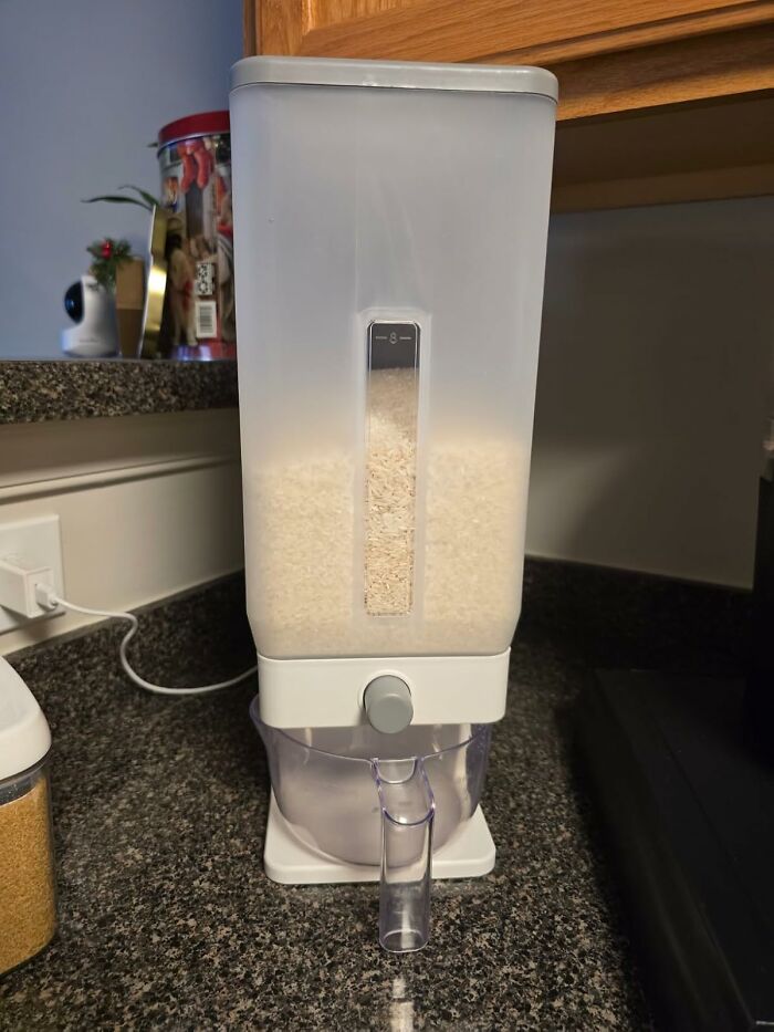 Rice dispenser on granite countertop for organizing Costco purchases.