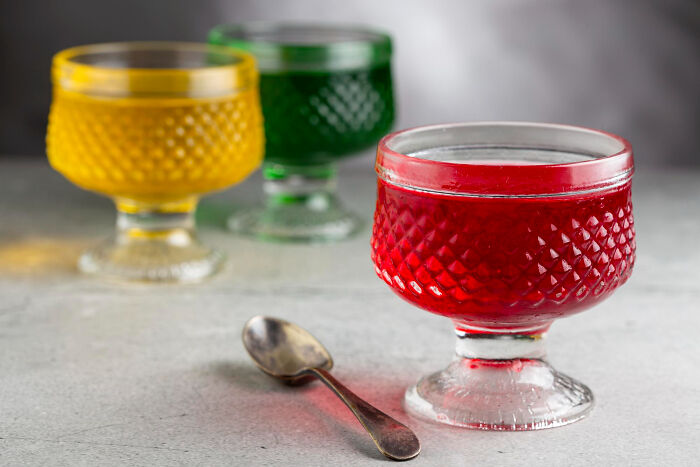 Colorful jello in fancy glass cups with a spoon, perfect for harmless April Fools' pranks.