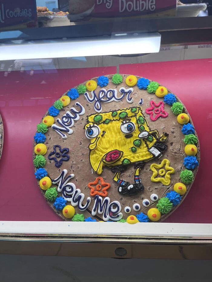 Funny baking fail: cake decorated with a humorous cartoon character, saying "New Year, New Me."