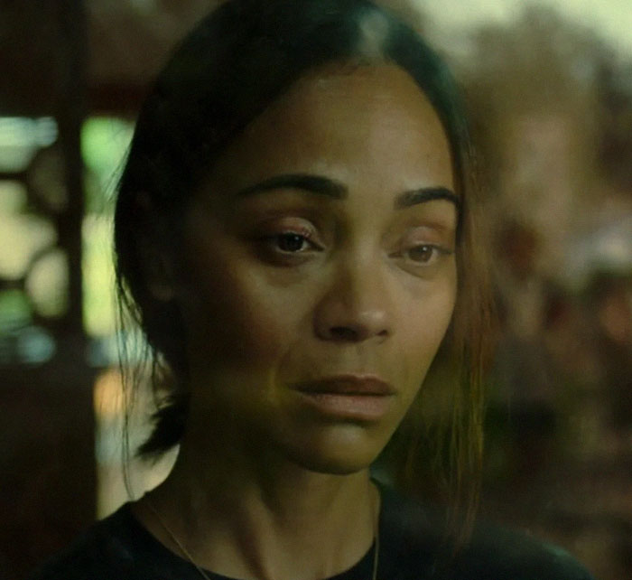 Woman looking somber through a window, related to Oscars controversy apology.