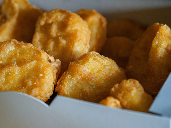 Golden chicken nuggets in a box, representing a popular lazy meal choice.