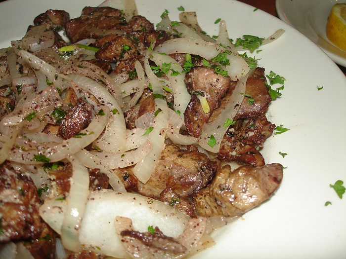 Old-school dish with cooked liver and onions, garnished with herbs, evoking nostalgic memories.