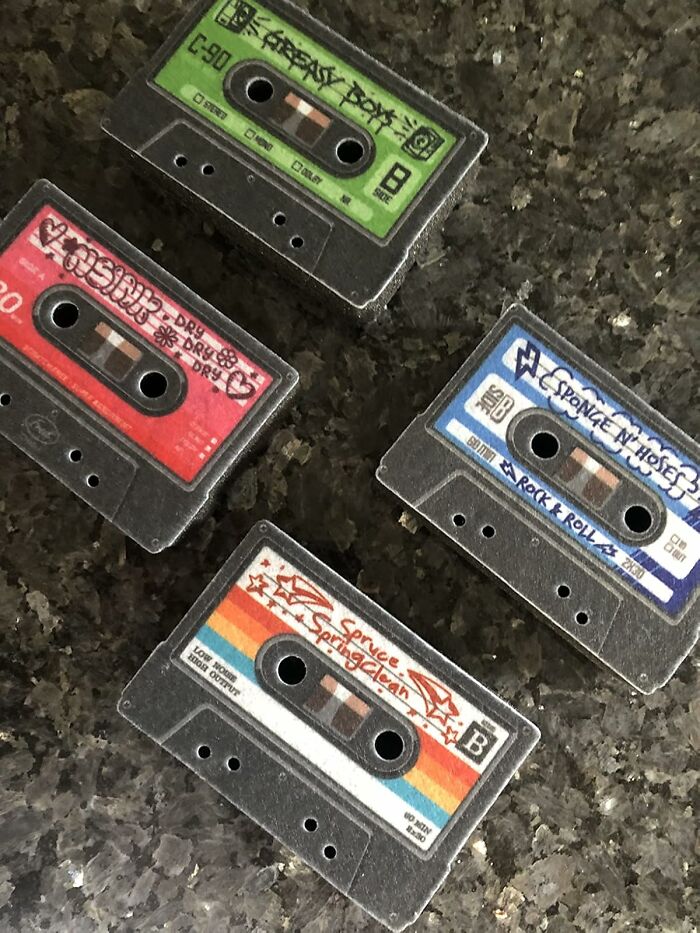 Four vintage cassette tapes on a dark surface, evoking 90s nostalgia.