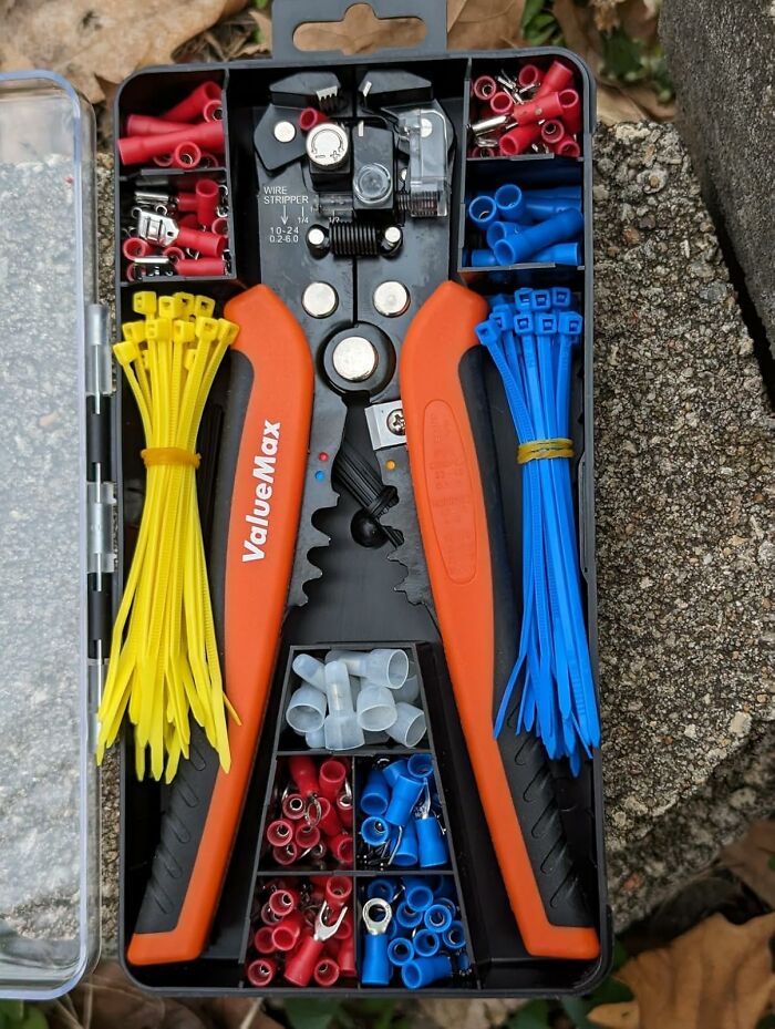 Tool kit with easy-to-learn life skills items, including a wire s******r and assorted connectors in a compact case.