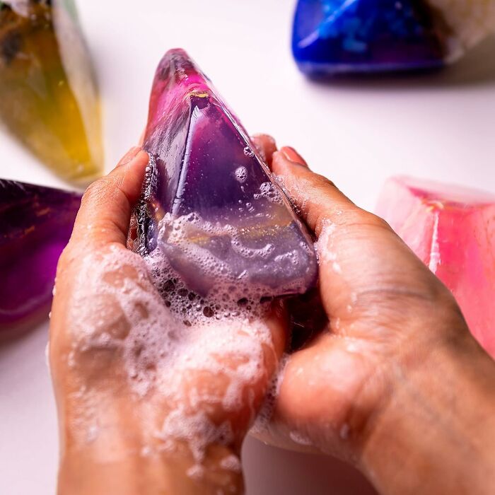 Hands holding a unique purple gemstone soap, a show-stopping find that sparks curiosity.