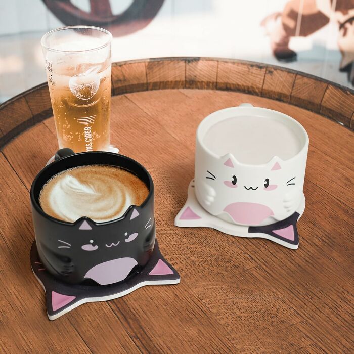Cat-themed mugs on a table, with a glass of beer, showcasing playful Yobro finds.
