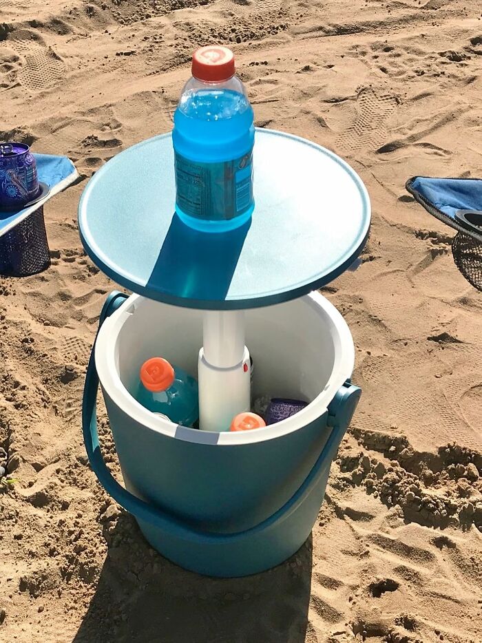 Dual-function beach cooler bucket with drinks, showcasing versatile tools for unexpected tasks on the sand.