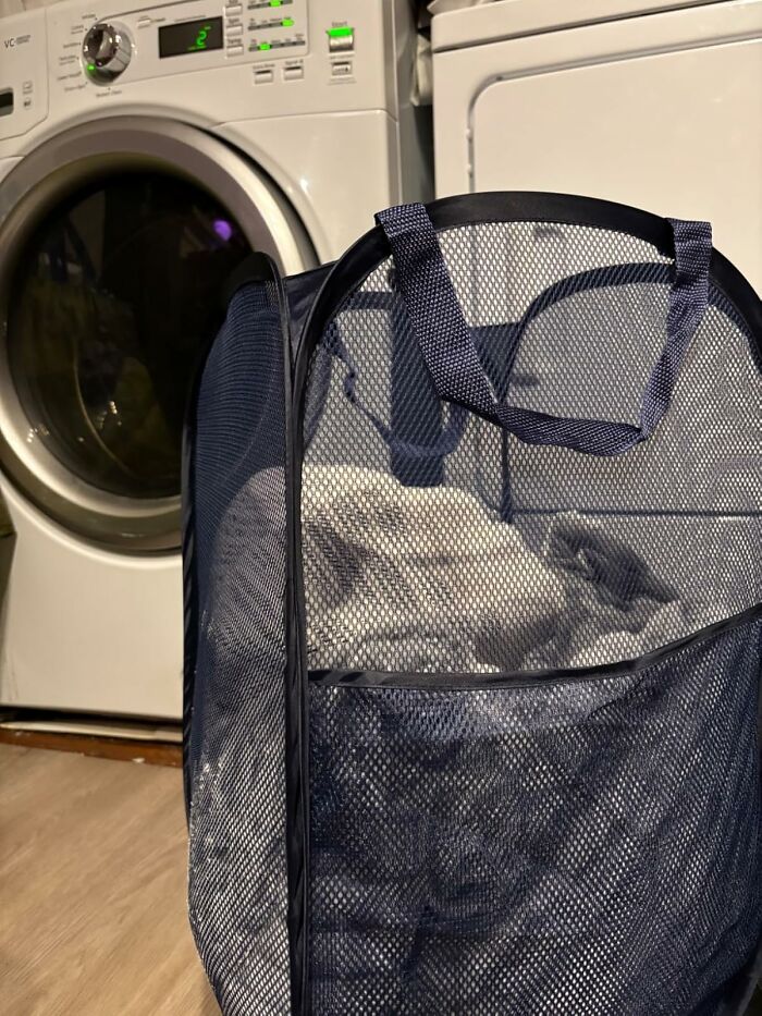 Mesh laundry basket in front of a washing machine, illustrating ultra-specific product utility.