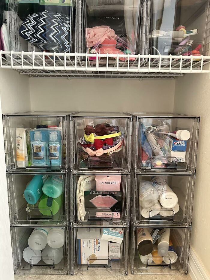 Organized bathroom shelf with plastic bins holding beauty and hygiene products.