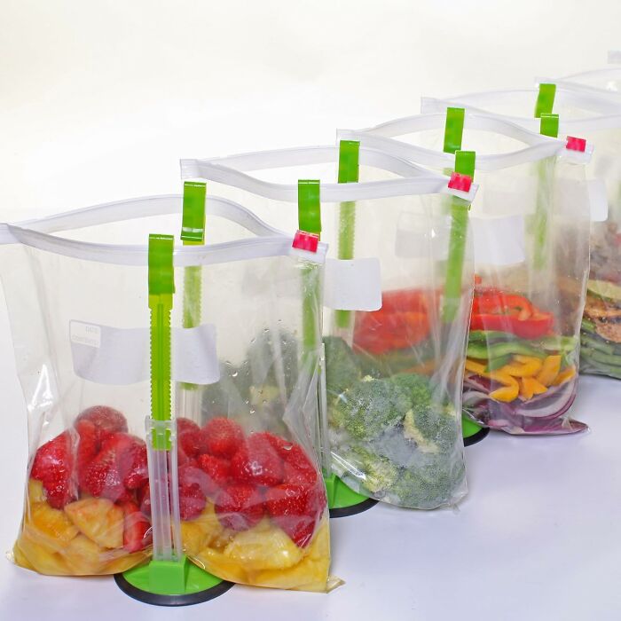 Plastic bags holding various fruits and vegetables with stand-up holders, showcasing handy tools for kitchen tasks.