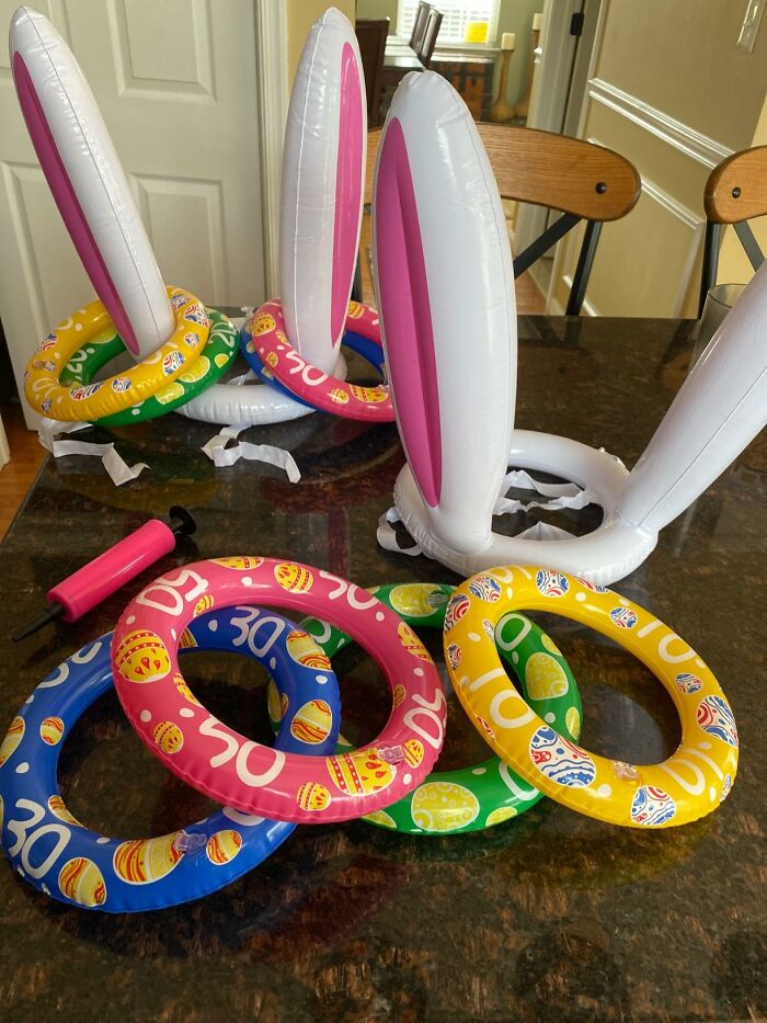 Inflatable bunny ears and colorful rings for a fun Easter game on a table.