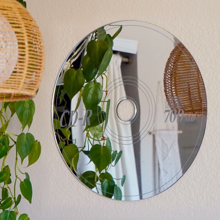 CD mirror decor with lush green leaves, reminiscent of 90s kids' nostalgia, reflecting a cozy room.