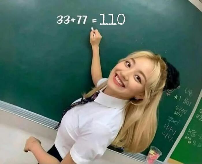 Blonde woman smiling at chalkboard with incorrect math equation, a literal meme humorously illustrating basic math error.