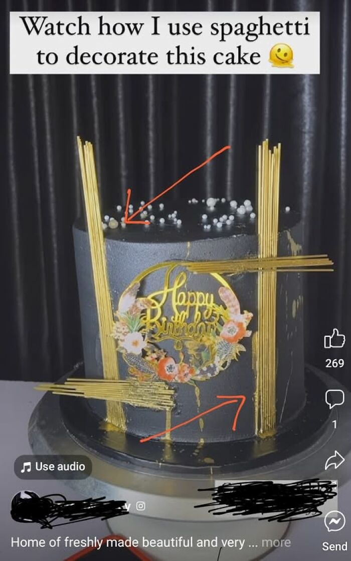 Black cake decorated with spaghetti sticks and a floral birthday topper, highlighting a unique baking fail.