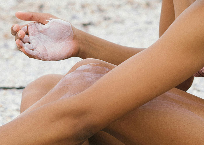 Applying lotion on leg, highlighting beauty tips for smooth skin.