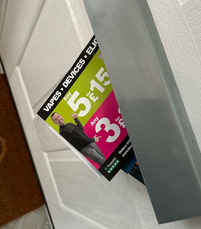 British leaflet for vape offers partially stuck in a door letterbox.