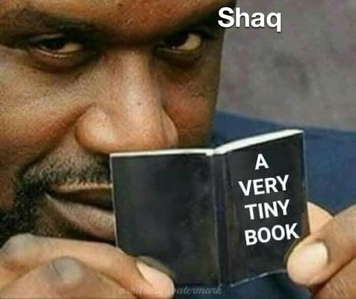 Man humorously reads a tiny book, showcasing literal memes.