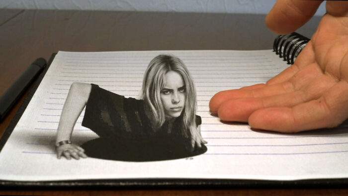 A 3D drawing by a professional German artist, showing a woman emerging from lined paper beside a hand.