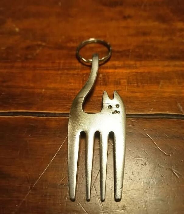 Cat-shaped fork keychain on wooden surface, an unusual thrifting find.