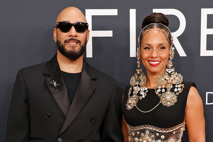 Two well-dressed celebrities posing together at an event, embodying celebrity couples.
