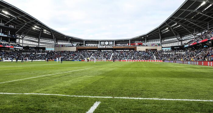 Soccer stadium filled with fans watching a match on a lush green field in one of the cathedrals of soccer.