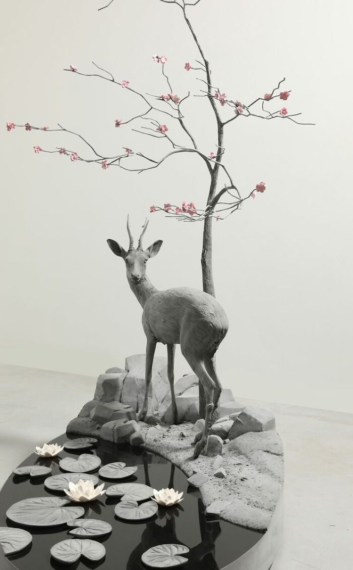 Monochrome sculpture by Hans Op De Beeck featuring a deer, tree with blossoms, and water lilies in a serene setting.
