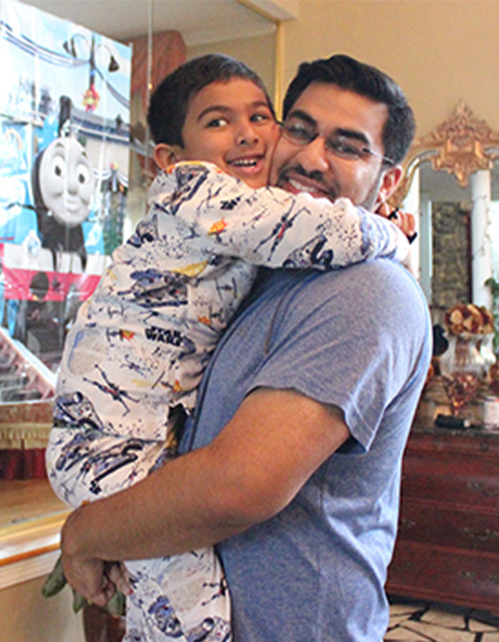 Smiling boy from Netflix 'Unsolved Mysteries' documentary joyfully hugs a man indoors. Smiling boy from Netflix 'Unsolved Mysteries' documentary joyfully hugs a man indoors.