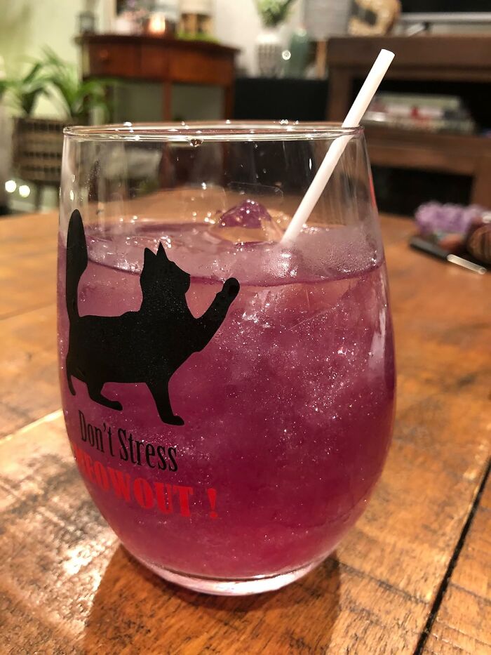 Purple sparkling drink in a glass with a black cat silhouette, showcasing a random Amazon find that sparks joy.