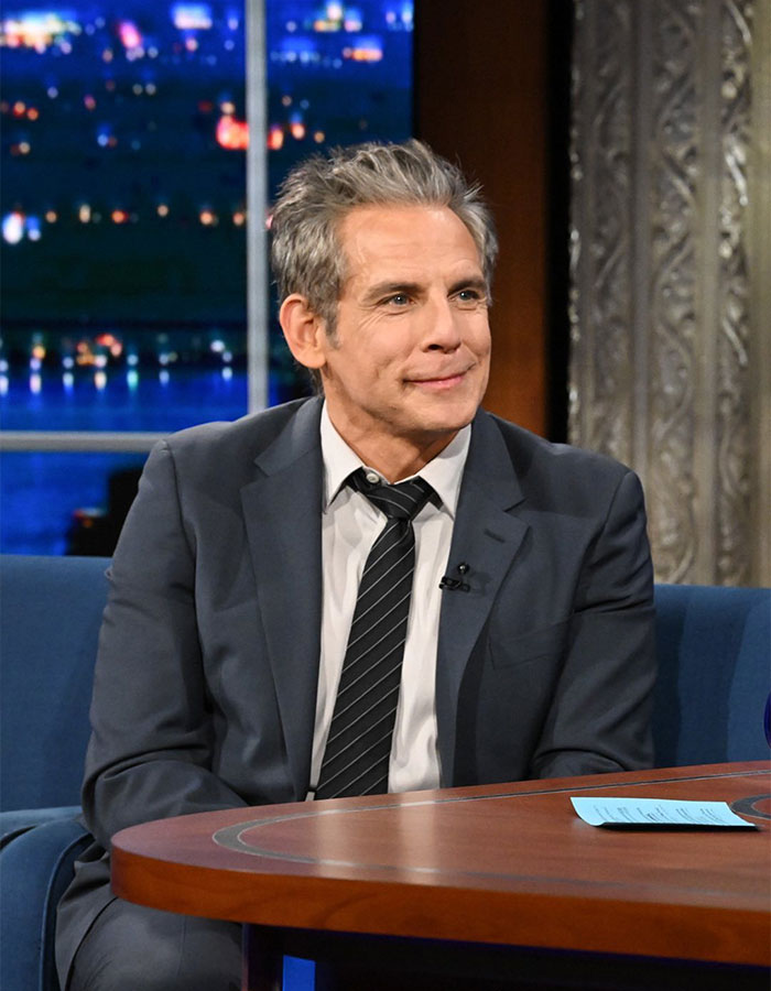 A person in a suit on a talk show set, representing talented nepo babies.