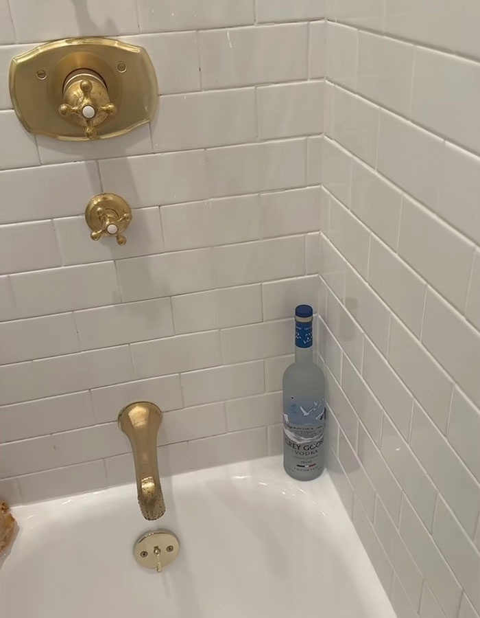 Gold shower fixtures with a vodka bottle in the corner, linked to Benny Blanco's unusual shower habit.