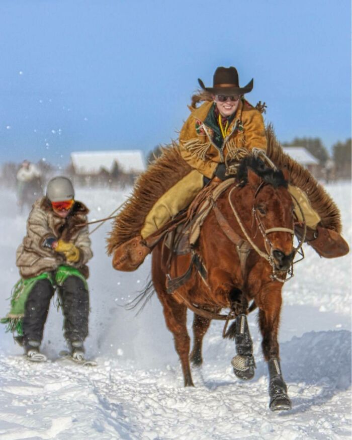 Winter snow activity in Canada: person horseback riding and pulling another on skis, showcasing unique cultural traditions.