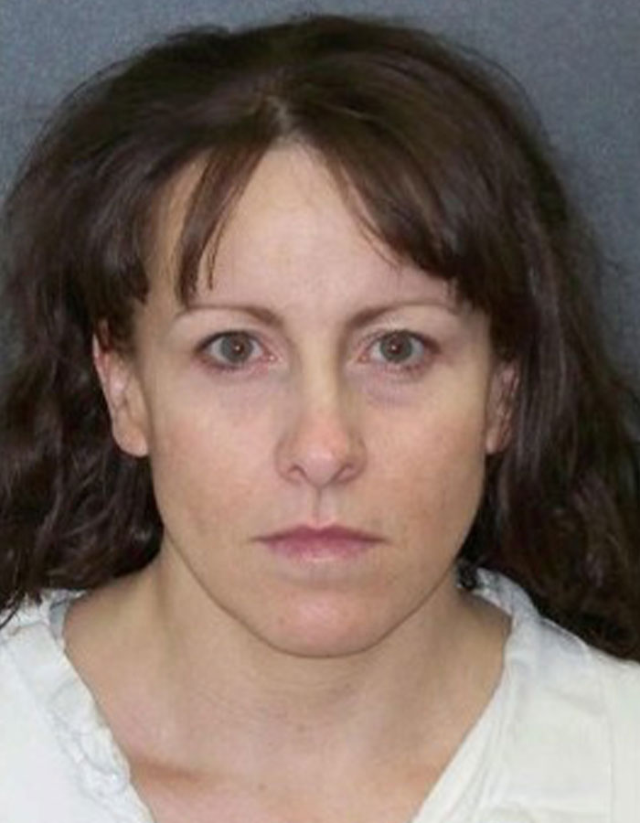 A woman with conviction overturned after 27 years, wearing a white shirt, with long brown hair, in a neutral expression.