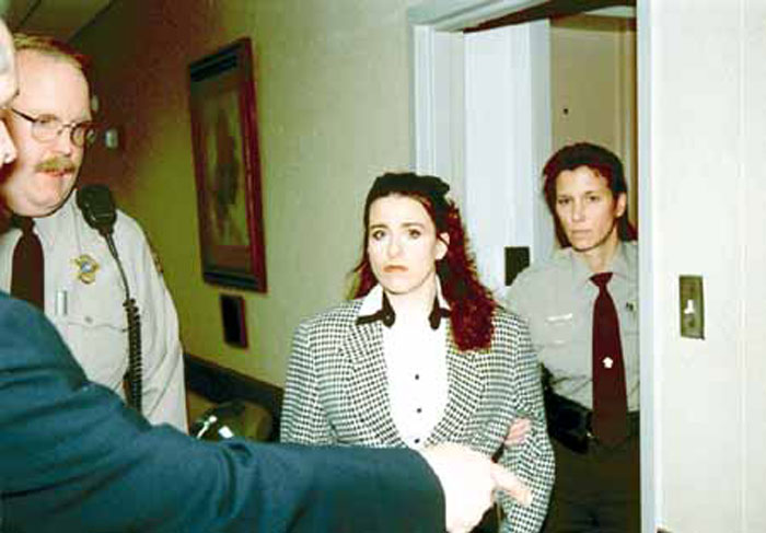 Woman escorted by officers, awaiting execution for 27 years, with conviction overturned.