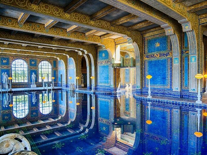 Ornate old American architecture featuring a luxurious indoor pool with blue and gold detailing.