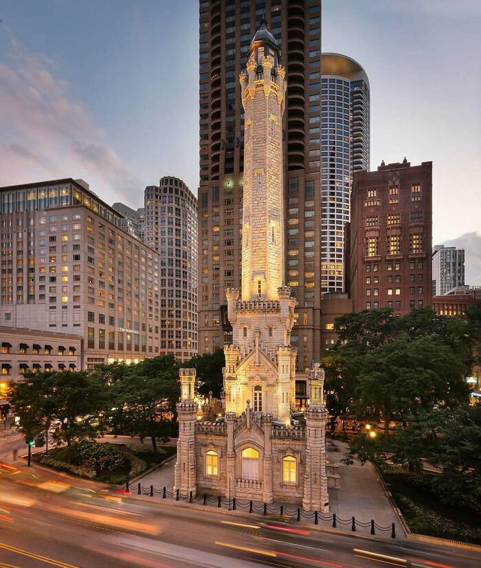 Illuminated historic tower amidst urban skyline, showcasing old American architecture.