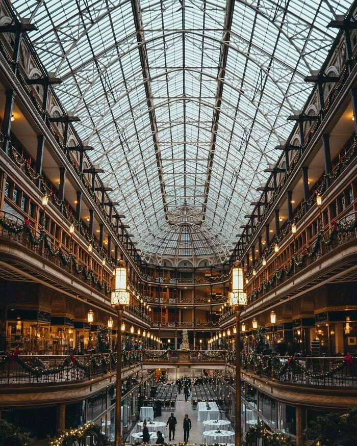 Interior of historic American architecture showcasing a large glass atrium with multiple floors and decorative lights.