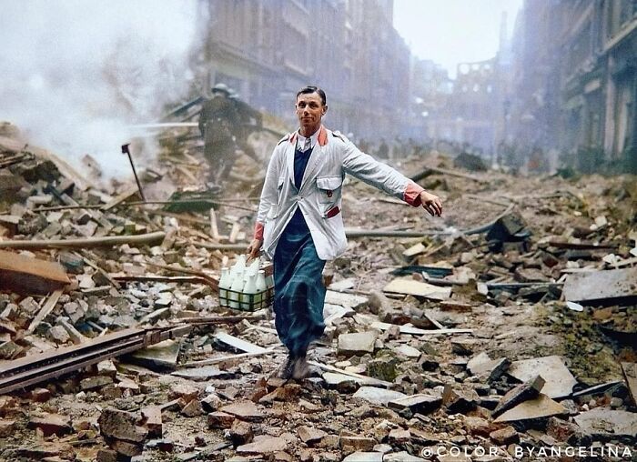 Milkman walking through rubble-strewn street during wartime, highlighting historical resilience amidst chaos.