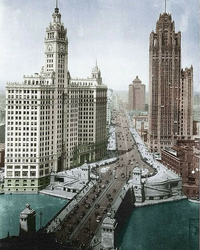 Vintage view of stunning American architecture featuring two tall historic buildings along a busy bridge.