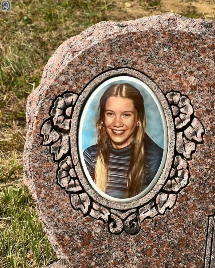 Lovely headstone portrait of a smiling woman in a striped shirt, set against a floral-engraved frame.