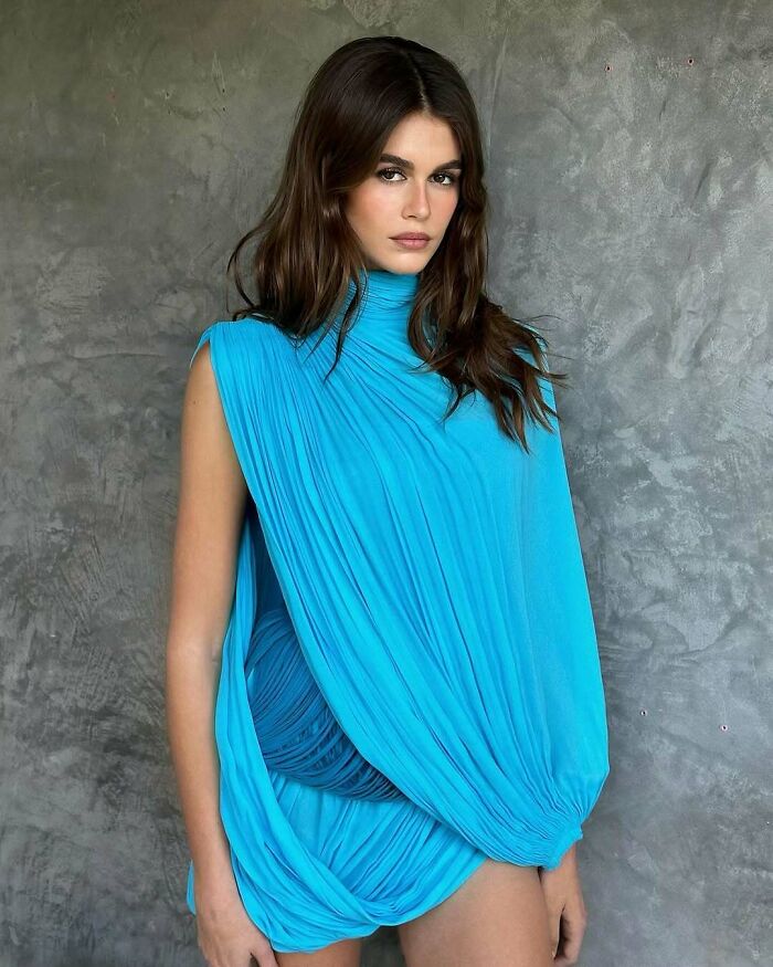 Fashionable individual in a vibrant blue dress with long hair, representing not-self-made celebs.