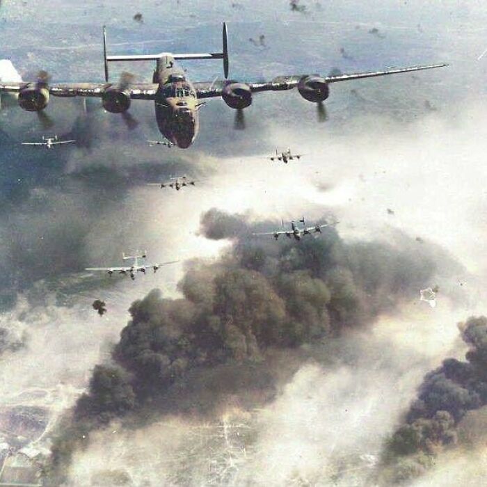 Historical picture of WWII bombers flying through smoke-filled skies, showcasing a pivotal past moment.