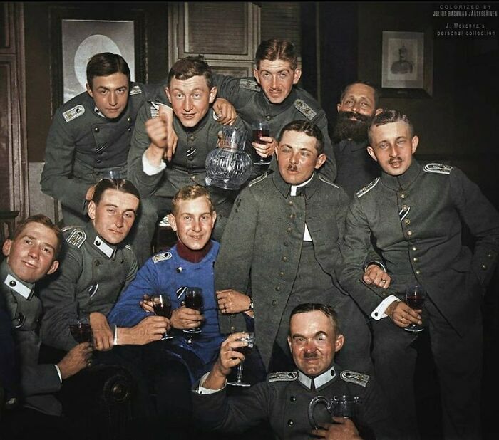 Group of soldiers in historical uniforms enjoying a drink, capturing a moment from the past.